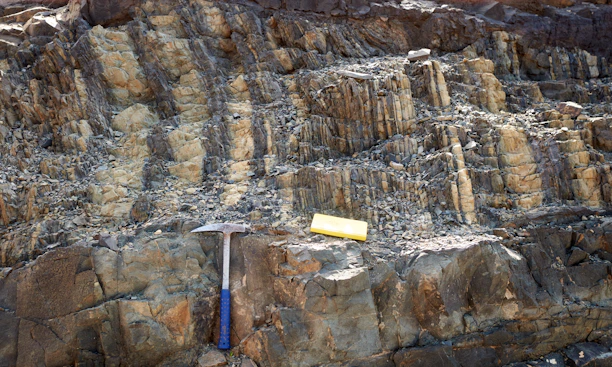 A geological scanning tool in use, scanning layered earth formations with digital readouts visible.