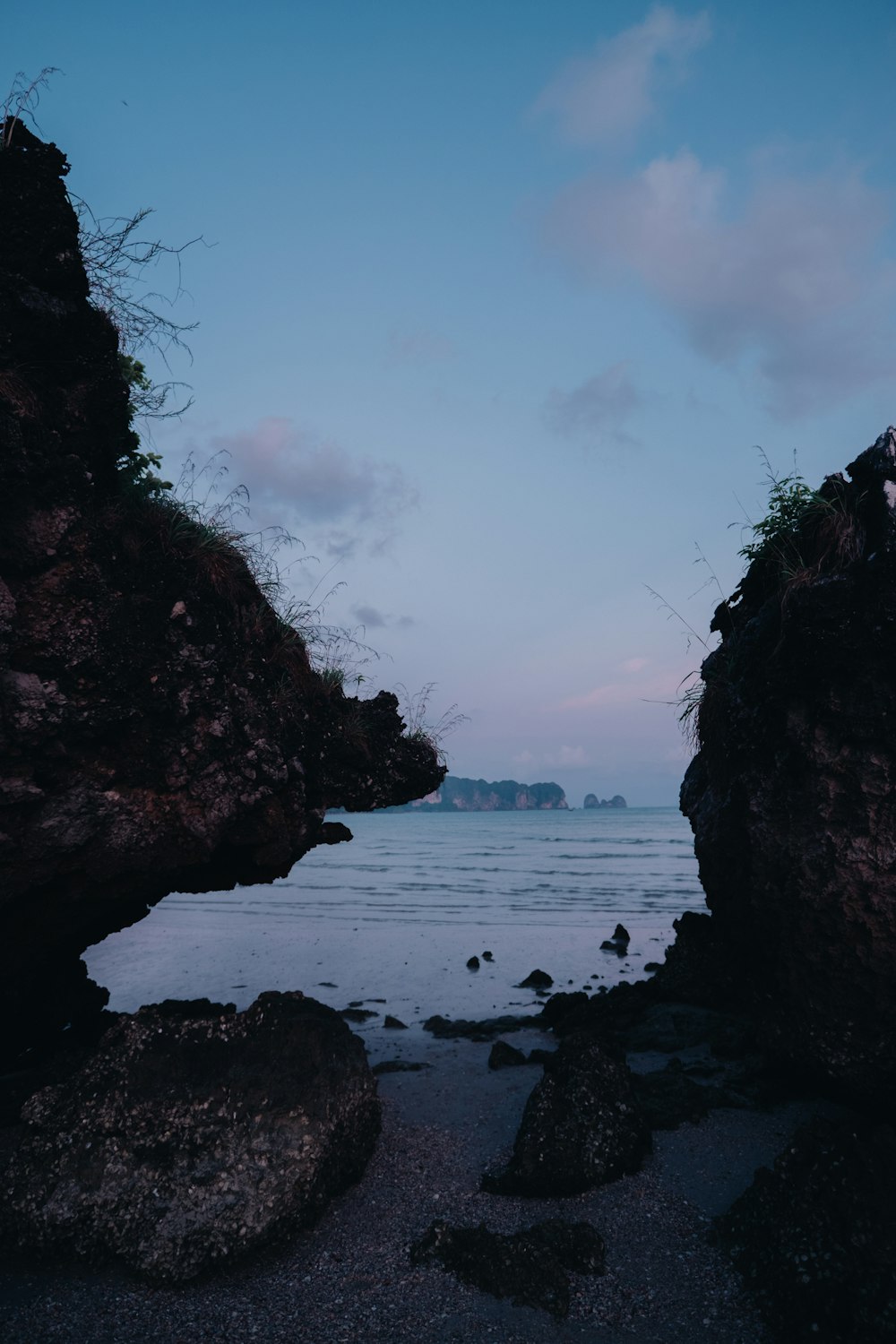 a view of a body of water through some rocks