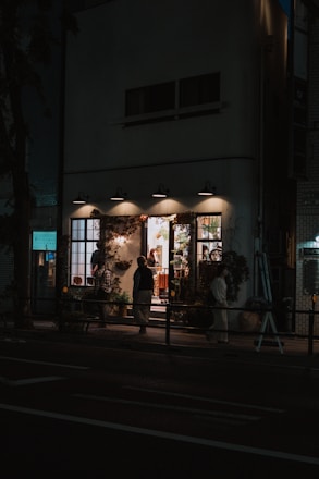A cozy small shop owner discussing marketing ideas with a consultant, warm lighting.