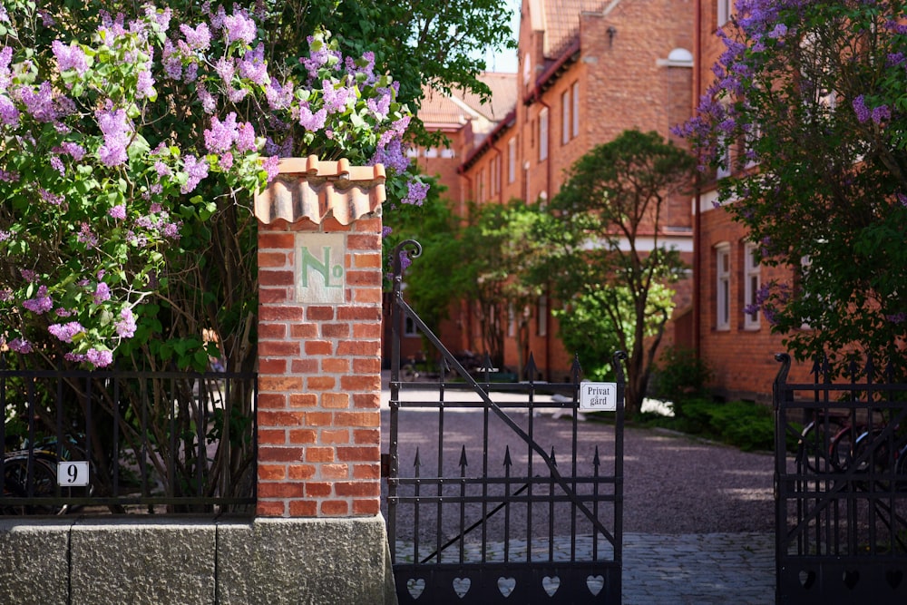 a brick gate with a sign on it in front of a brick building