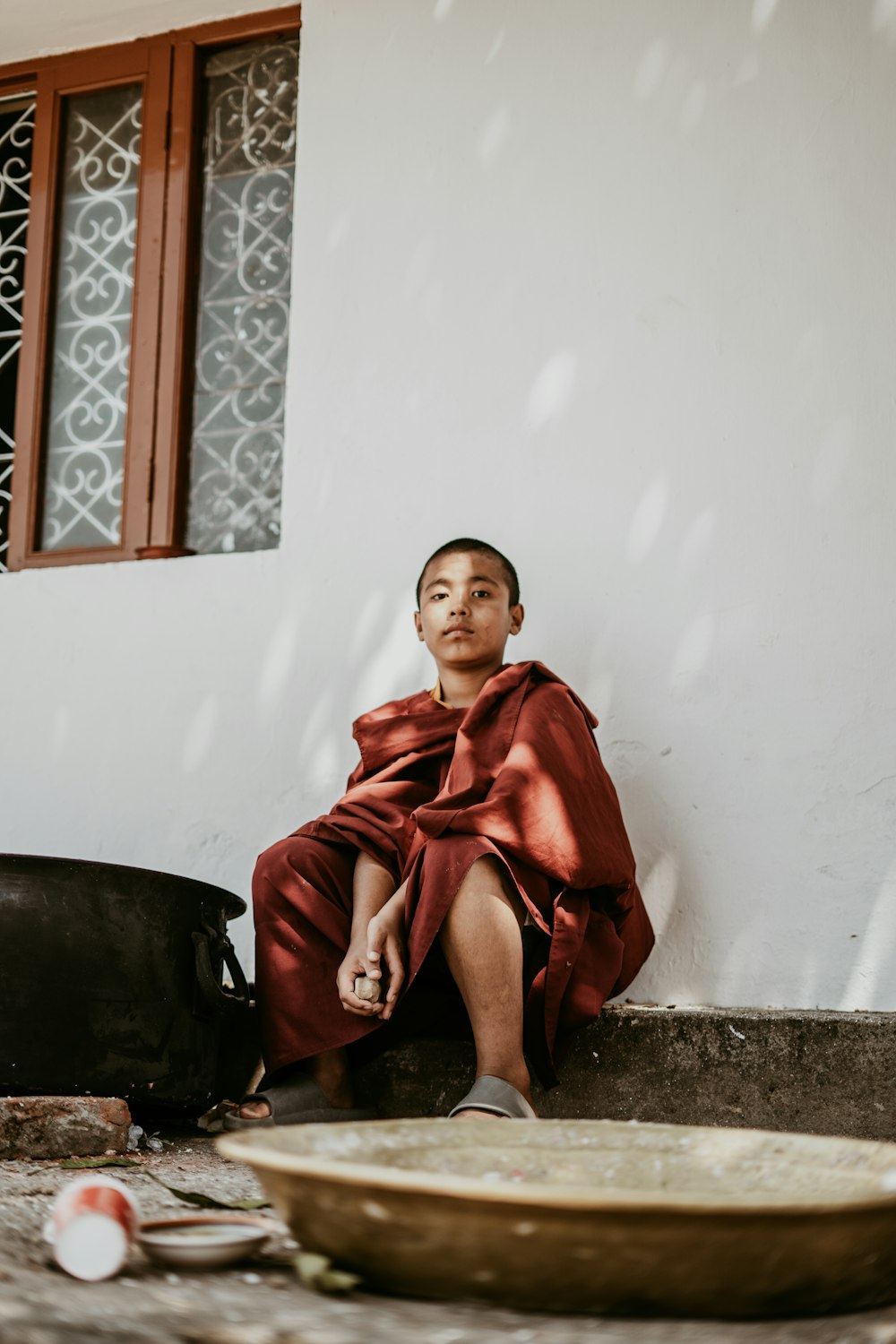 a woman sitting on the ground next to a bowl