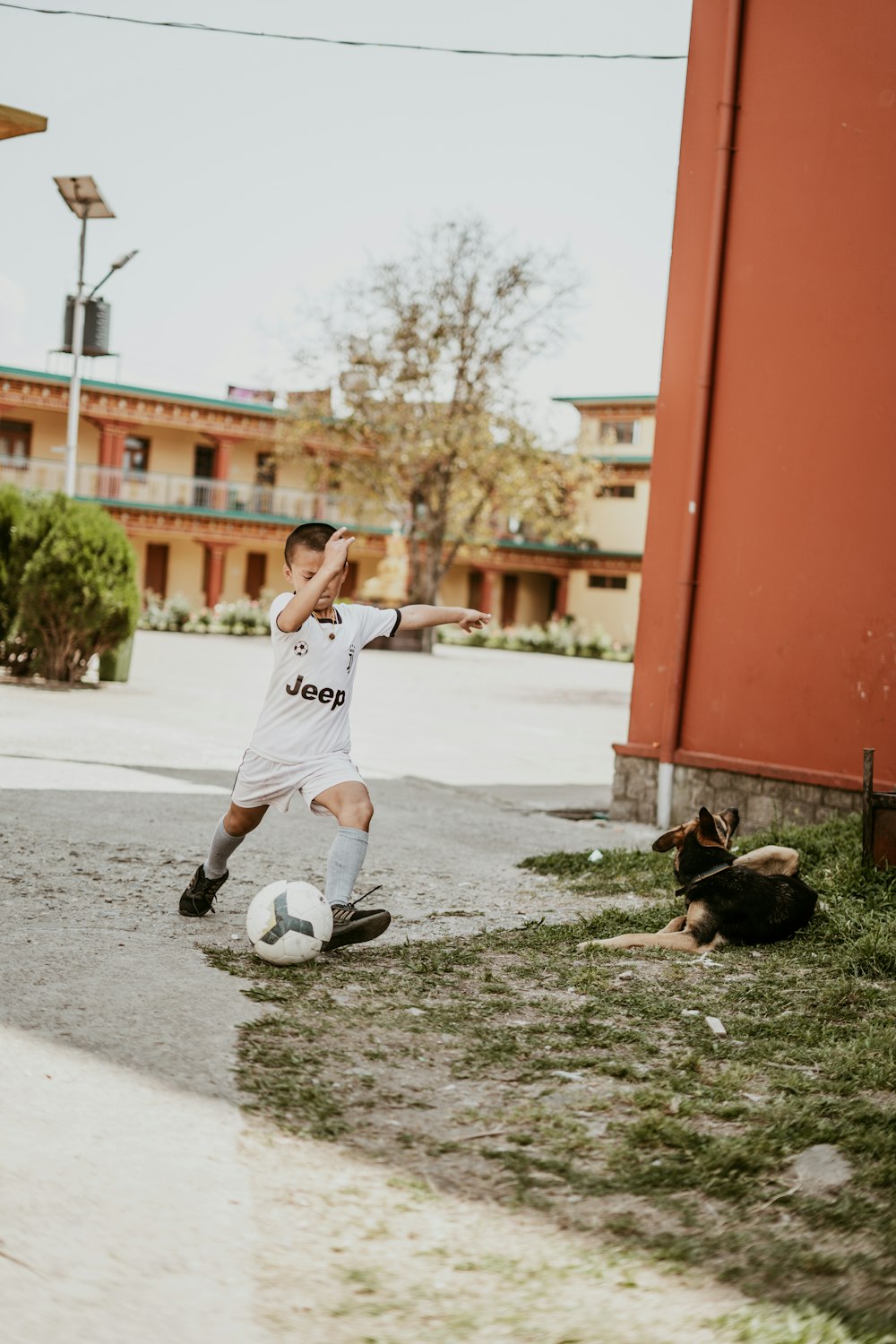 a young man kicking a soccer ball on a field