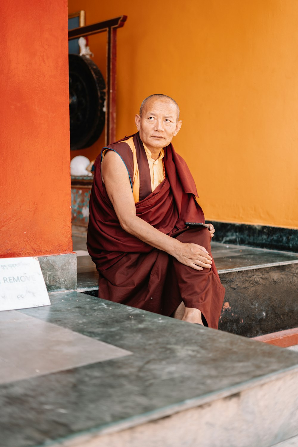 a man in a monk outfit sitting on steps