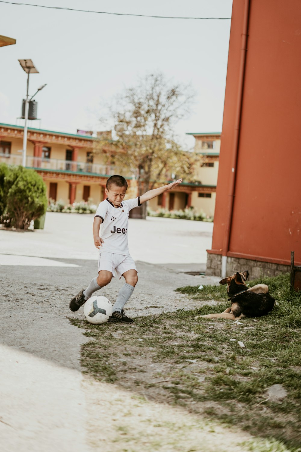 a young boy kicking a soccer ball on a field