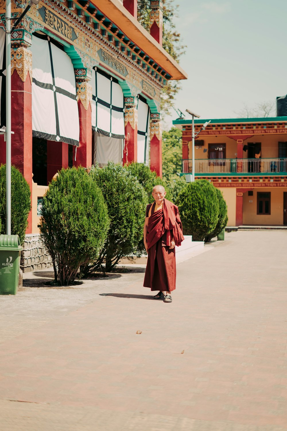 a woman in a red robe is walking in front of a building
