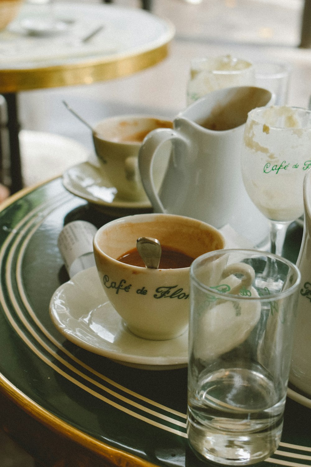 a table topped with cups and saucers filled with liquid