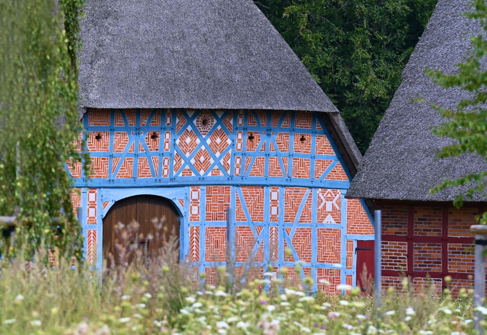 a blue and red building with a thatched roof