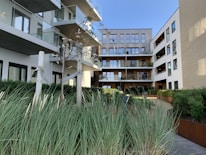 Completed apartment complex with balconies and greenery around.