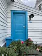 Wide shot of a newly installed blue exterior door on a suburban home.