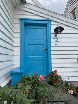 Wide shot of a newly installed blue exterior door on a suburban home.