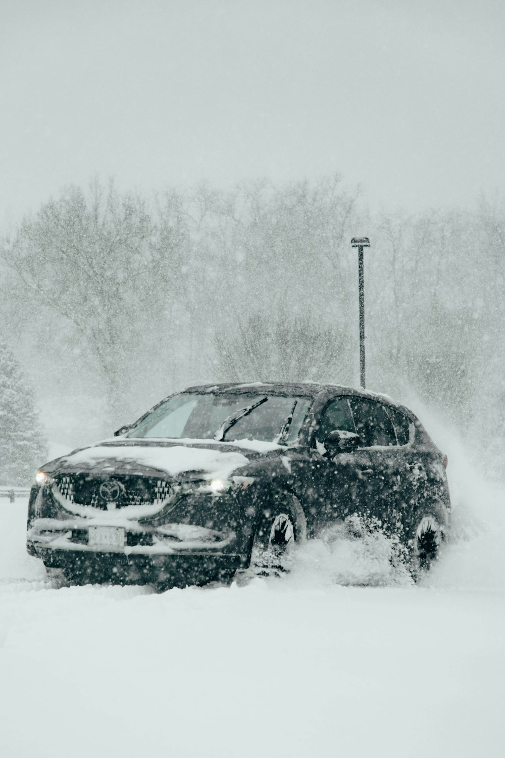 雪に覆われた駐車場を走る車