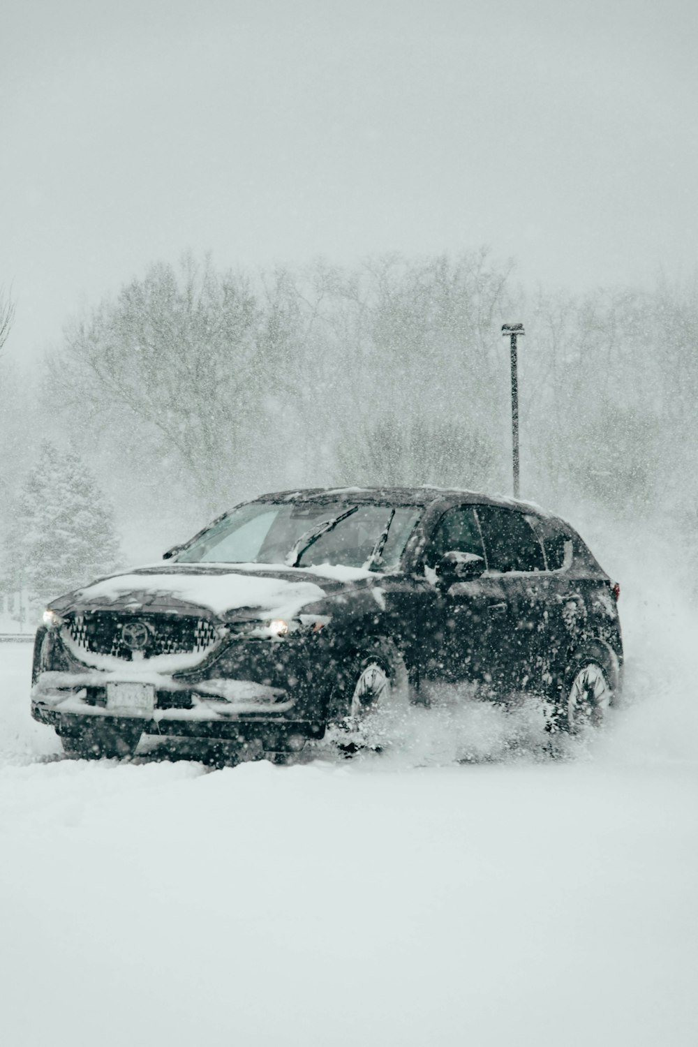 雪に覆われた駐車場を走る車