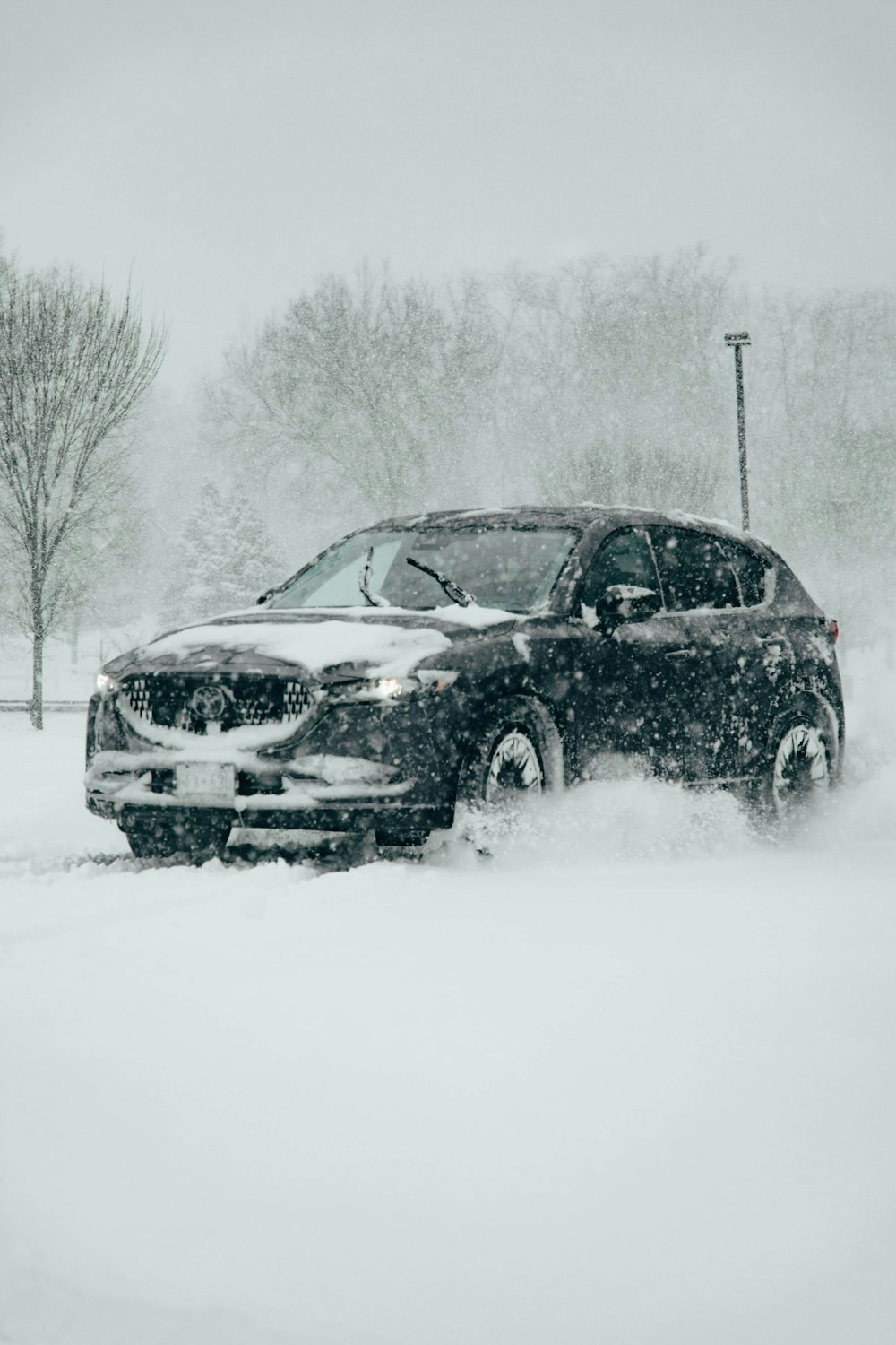 雪に覆われた駐車場を走る車