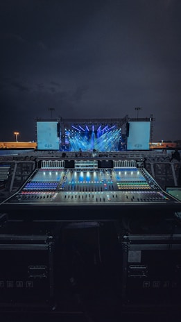 A vibrant Miami outdoor event setup featuring professional sound and lighting equipment glowing at dusk.