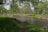 A peaceful nature scene with a flowing river and lush greenery.