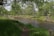 A peaceful nature scene with a flowing river and lush greenery.