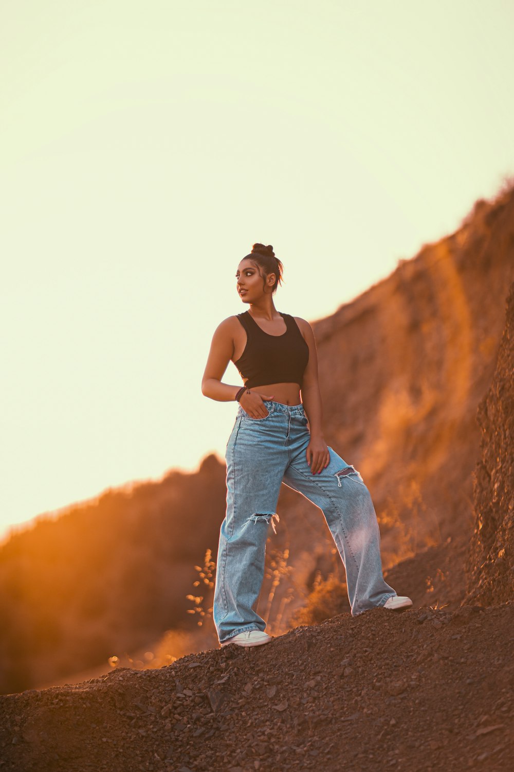 a woman standing on top of a dirt hill