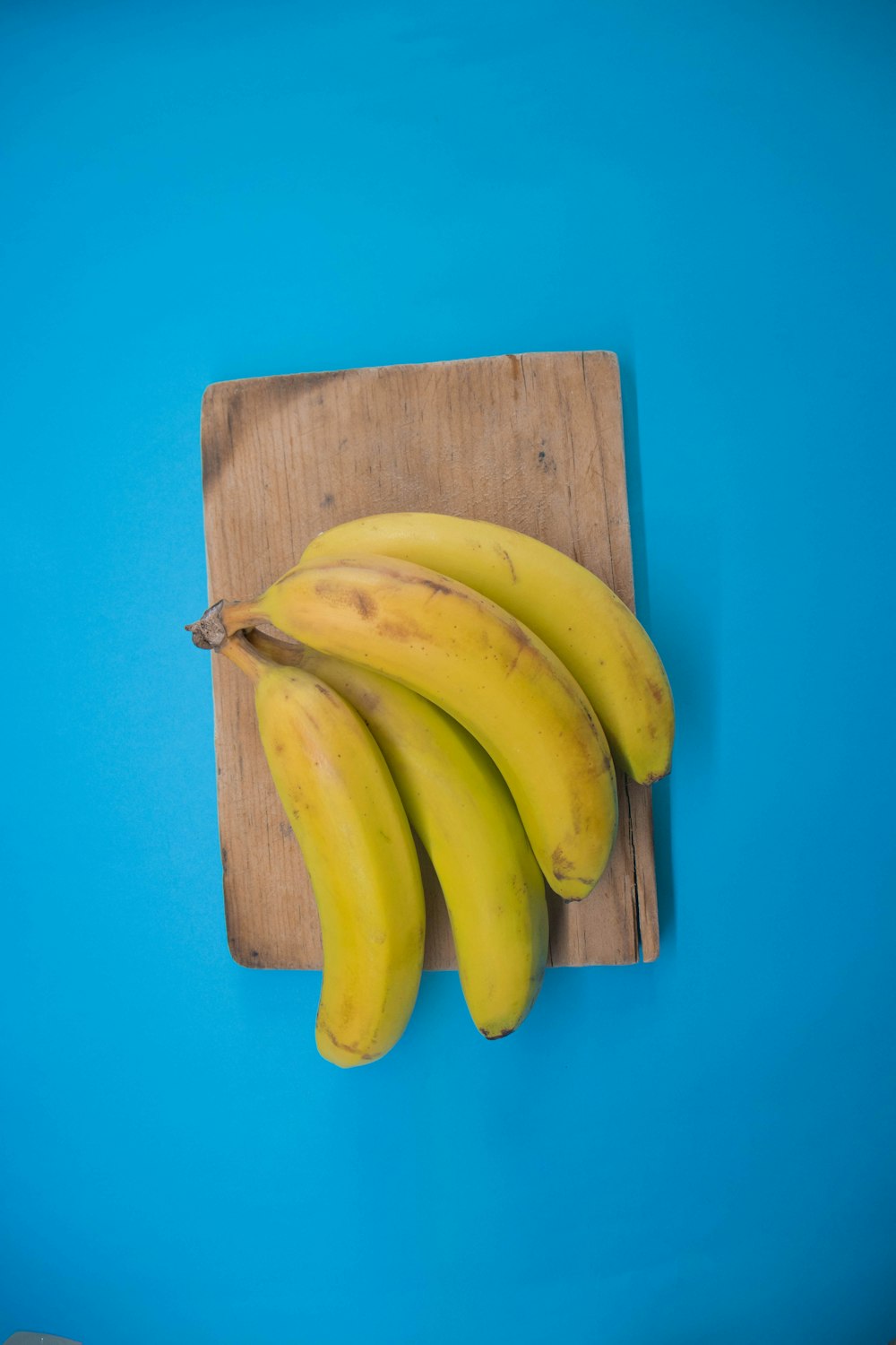 a bunch of bananas sitting on top of a wooden cutting board