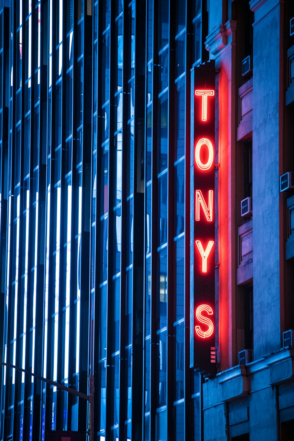 a tall building with a neon sign on it's side