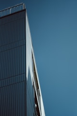 A sleek modern building under construction with clean lines and a clear sky backdrop.