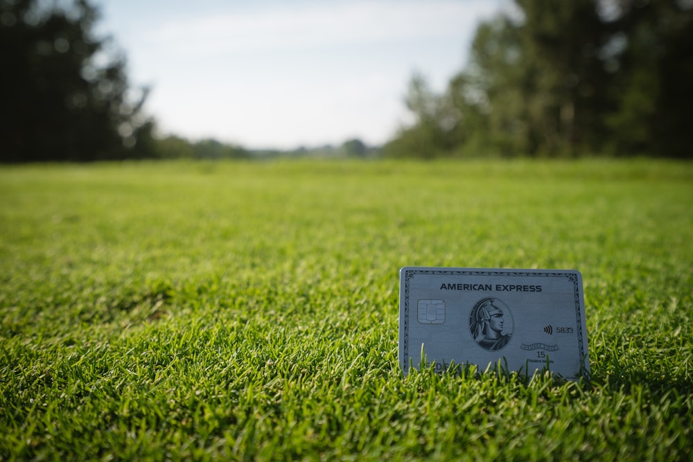 a credit card sitting on top of a lush green field