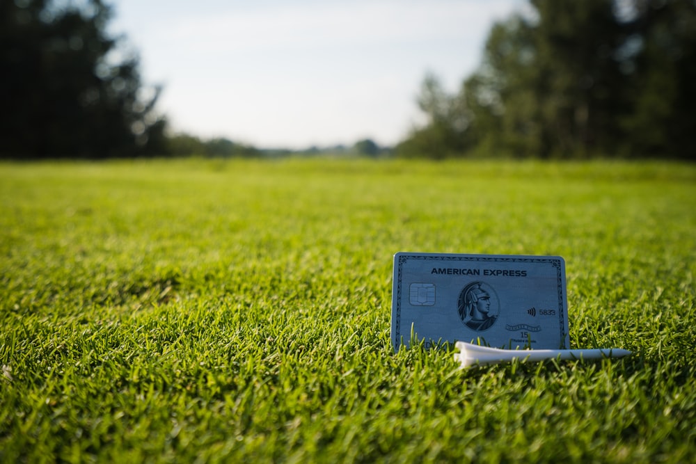 a credit card sitting on top of a lush green field