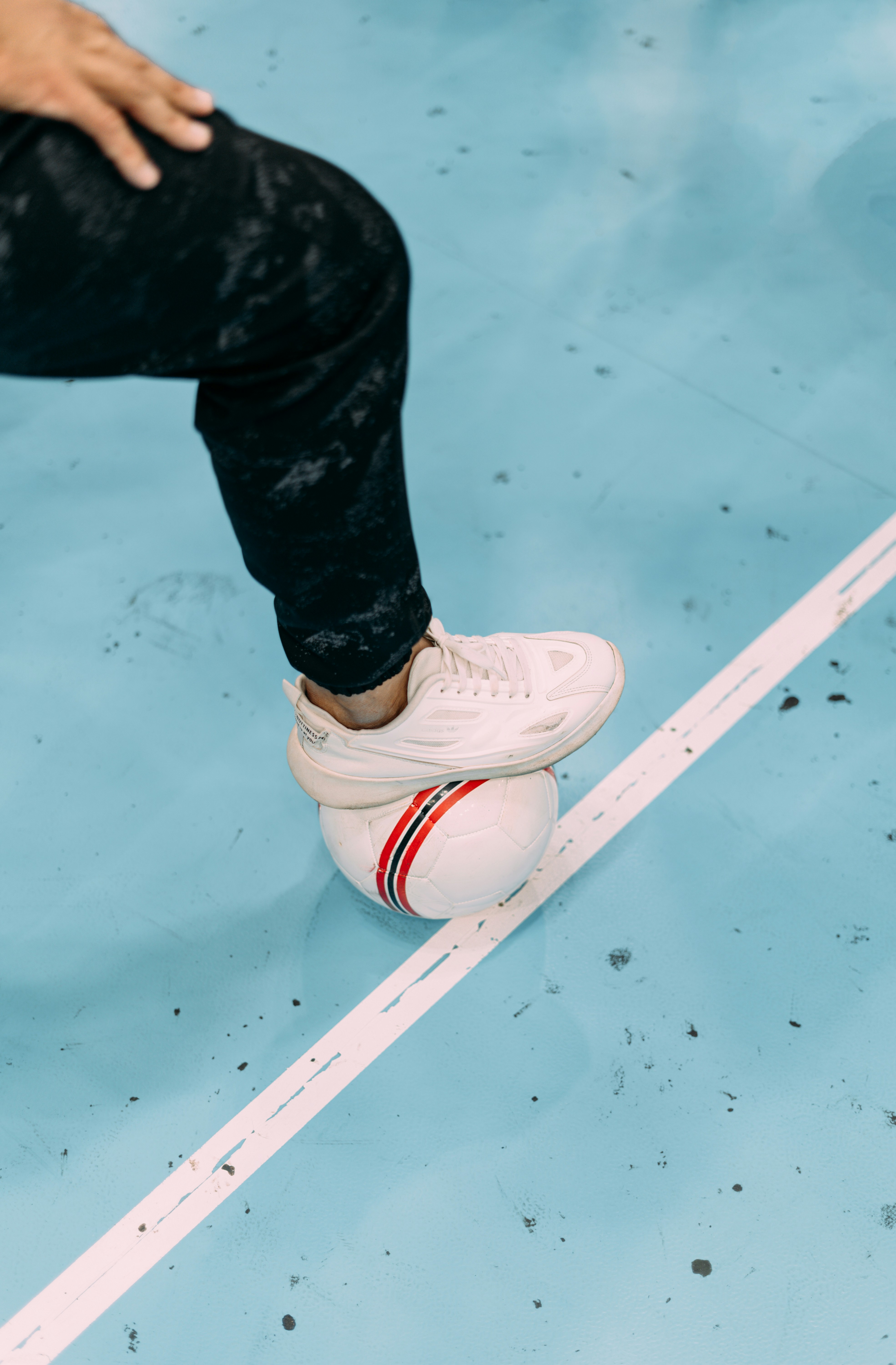 a person standing on top of a tennis ball on a court