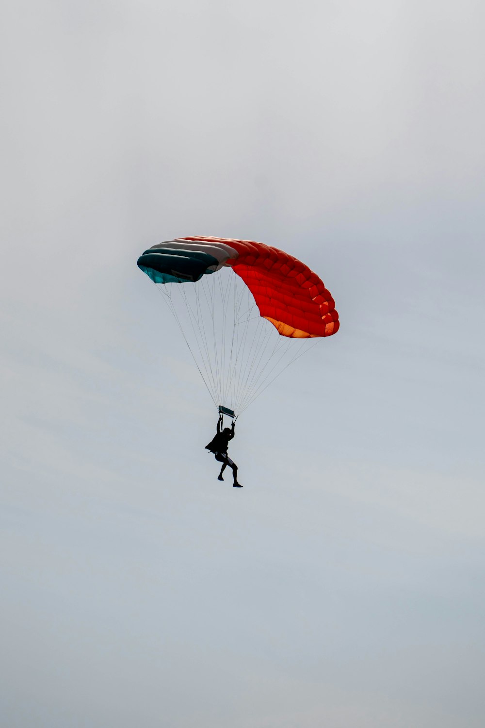 a person is parasailing in the air on a cloudy day