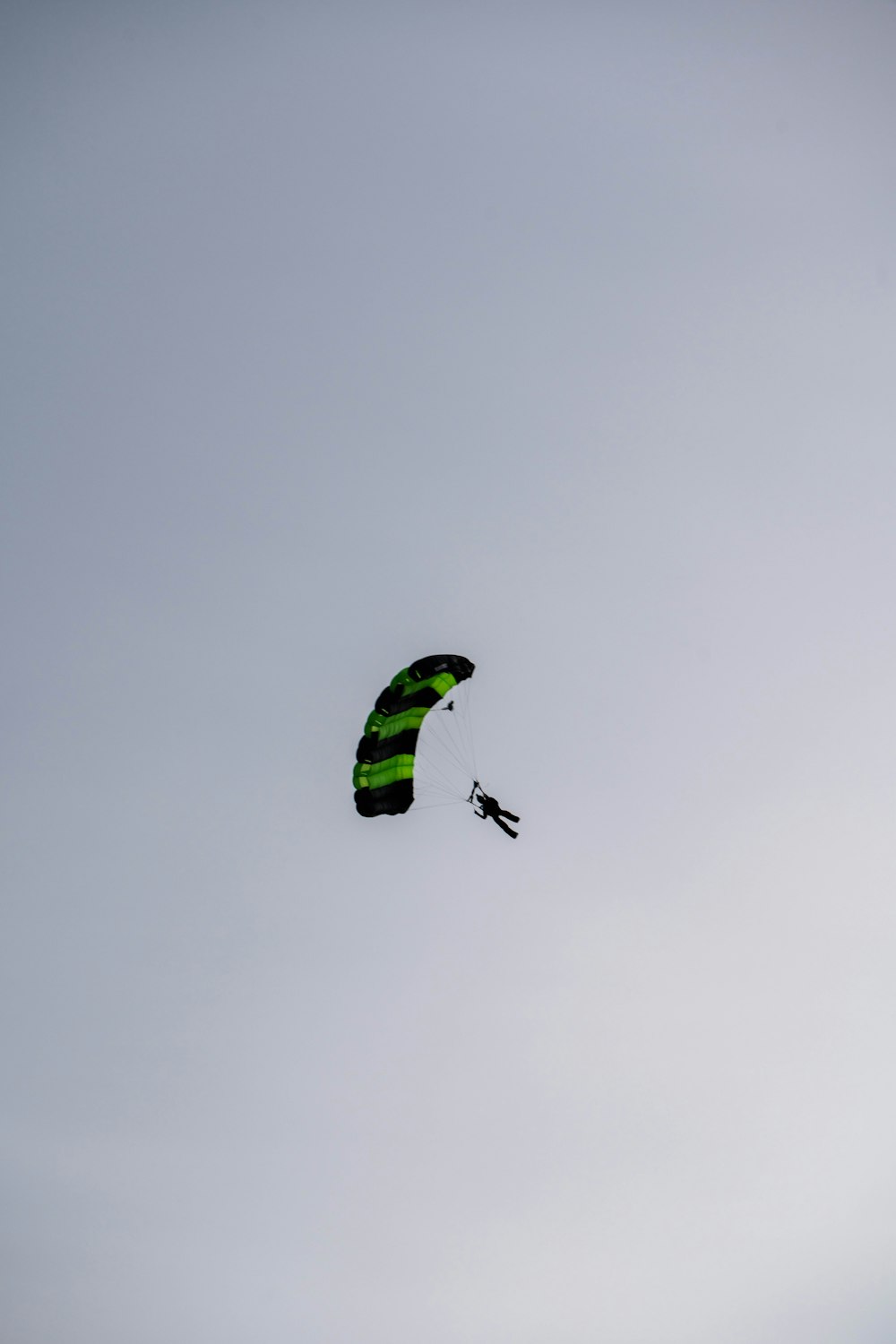 a person is parasailing in the sky on a cloudy day