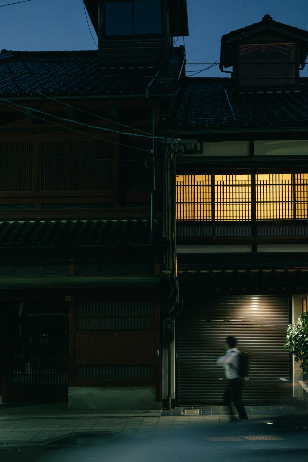 a man walking in front of a building at night