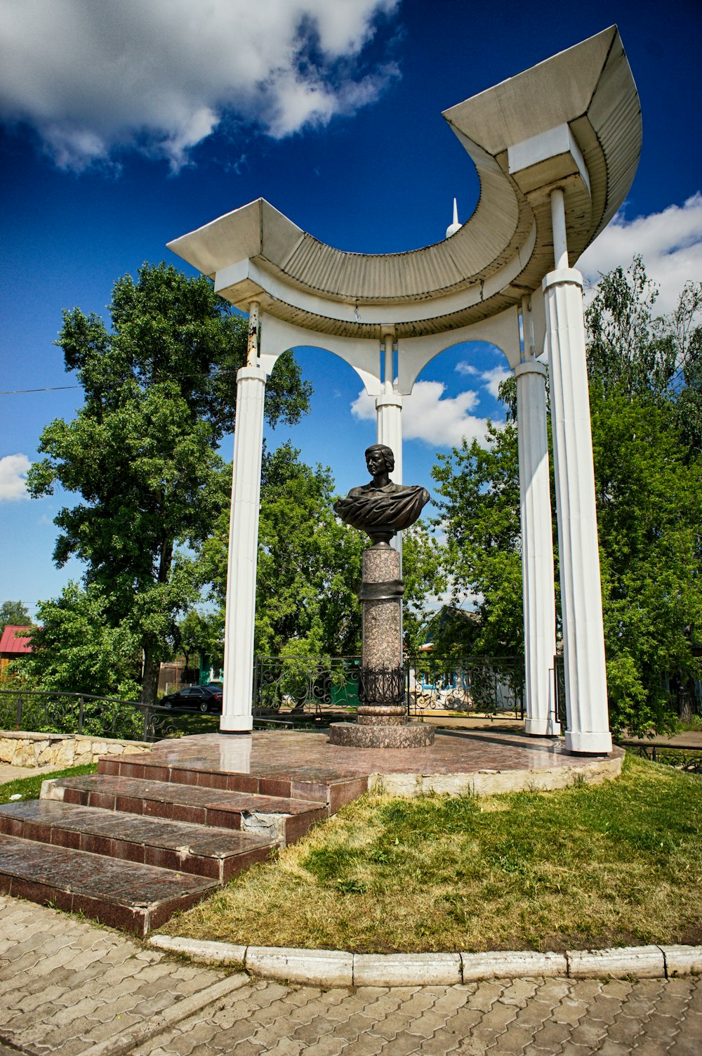Une statue d’un homme est au milieu d’un parc