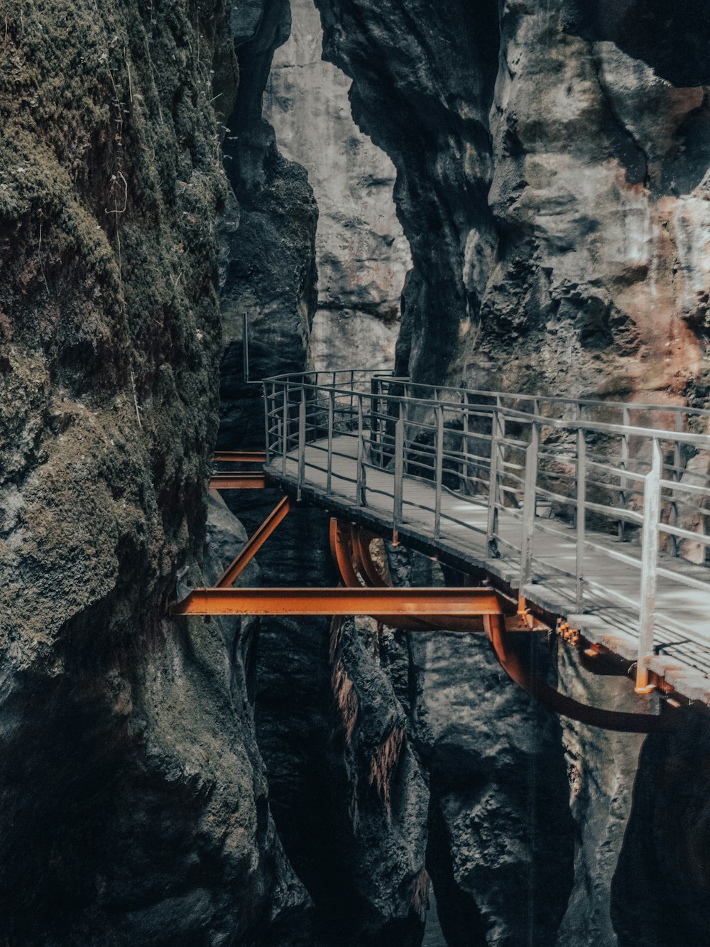 uma ponte de madeira sobre um cânion estreito em uma montanha