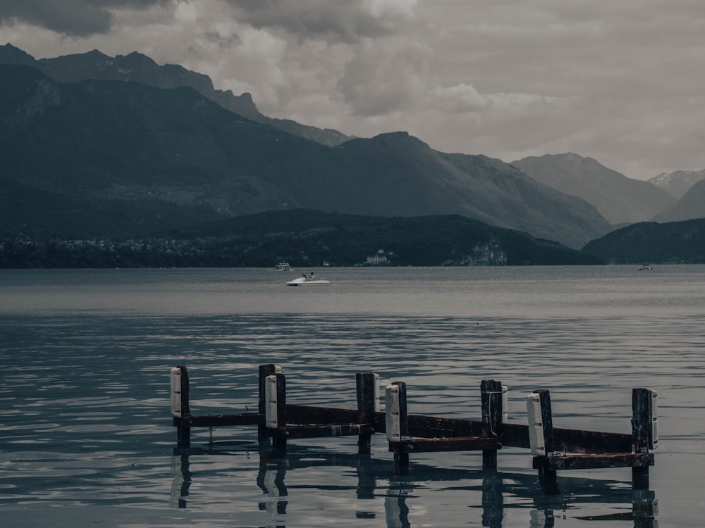 ein Dock in der Mitte eines Sees mit Bergen im Hintergrund