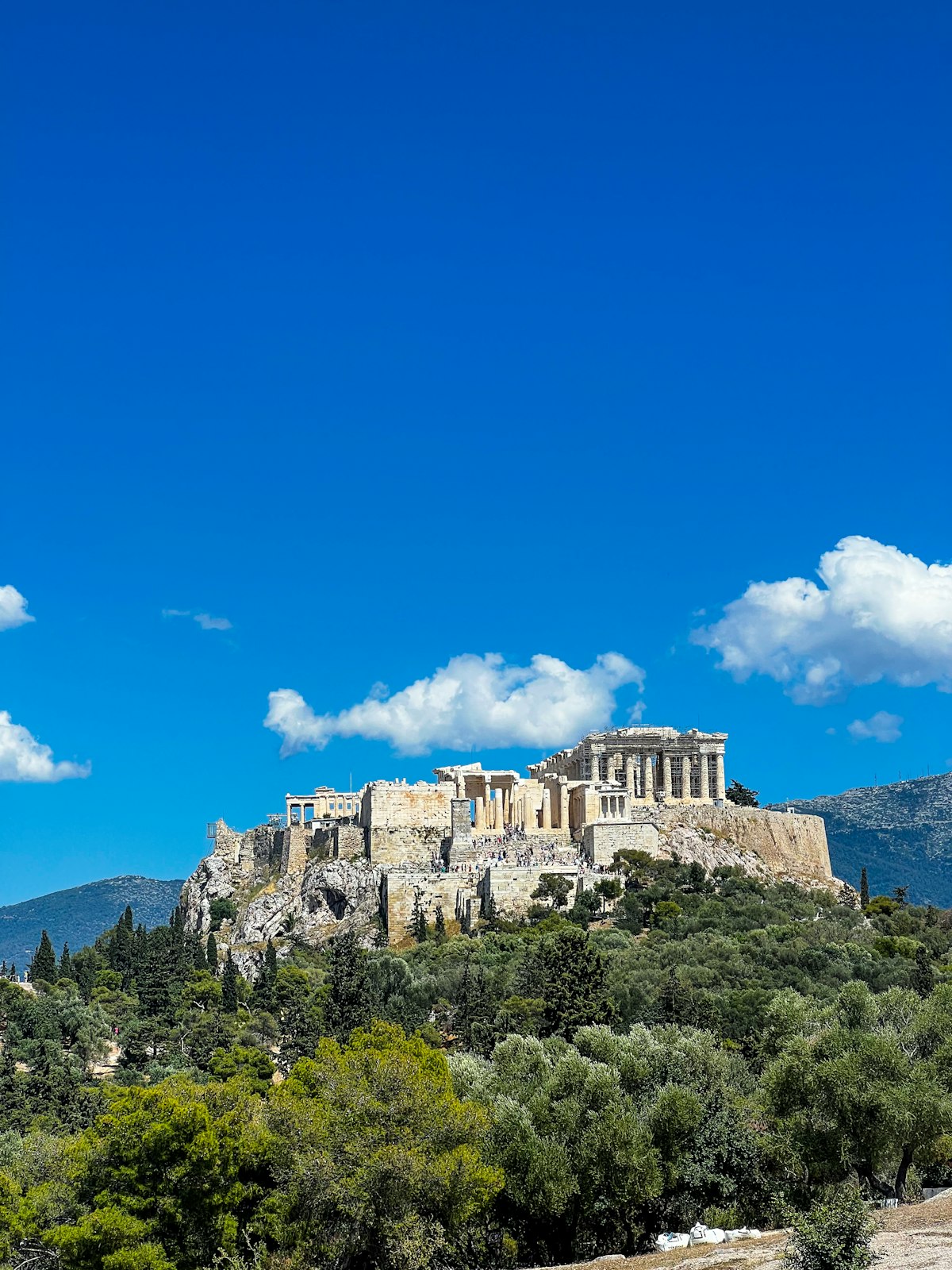Athens August — the Acropolis hill rising above the city under a clear blue sky at the height of summer