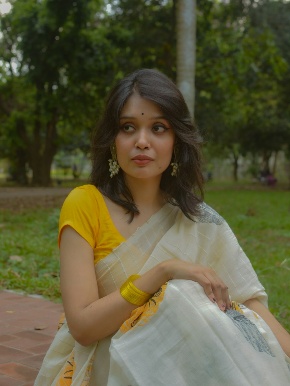 a woman in a yellow and white sari