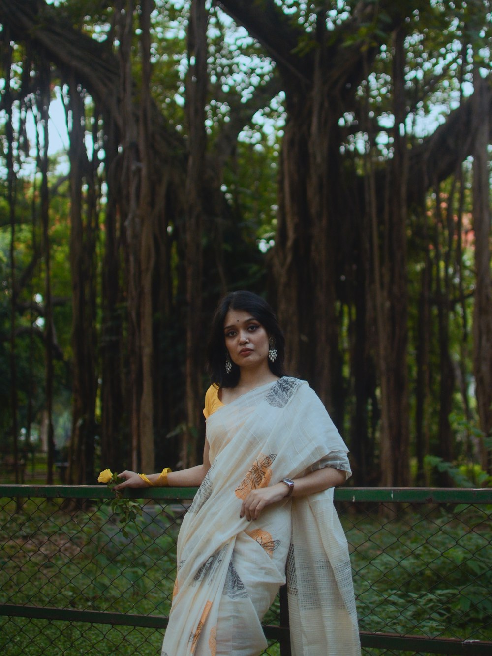 a woman in a white sari holding a banana