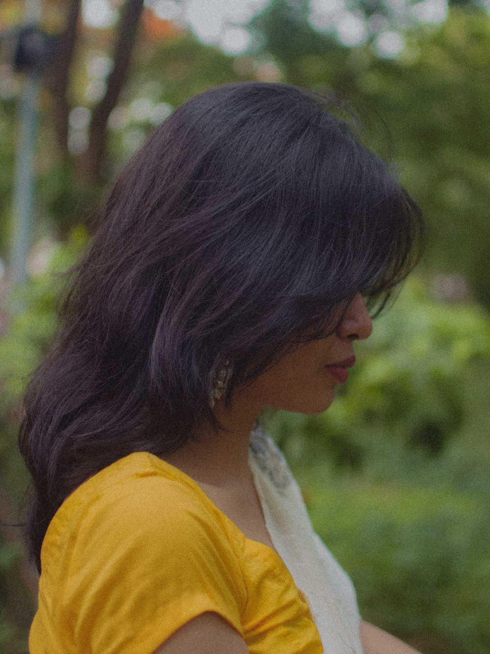 a woman in a yellow shirt is holding a cell phone