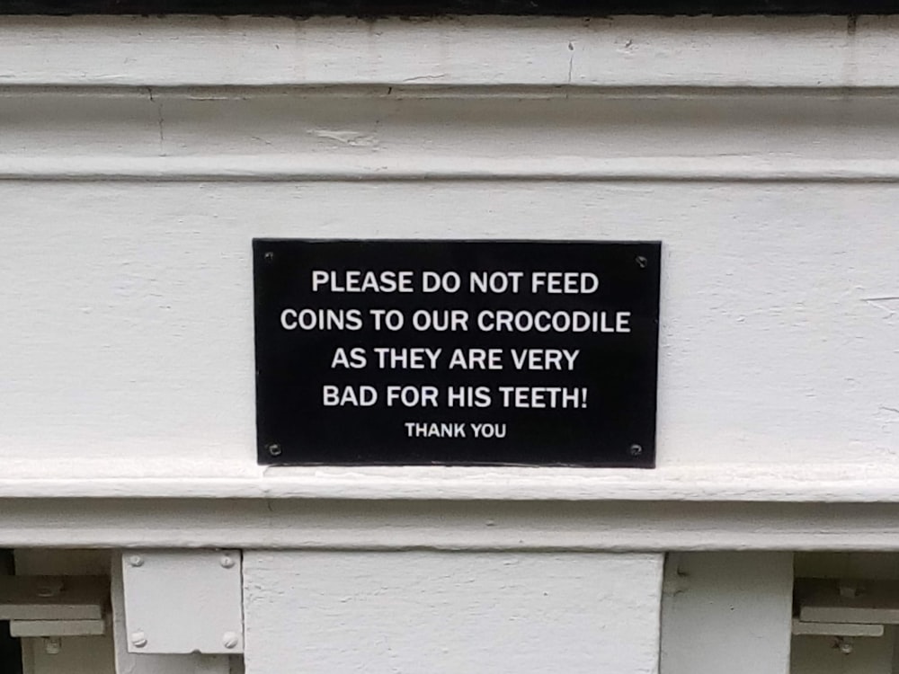 a sign on the side of a building that says, please do not feed coins