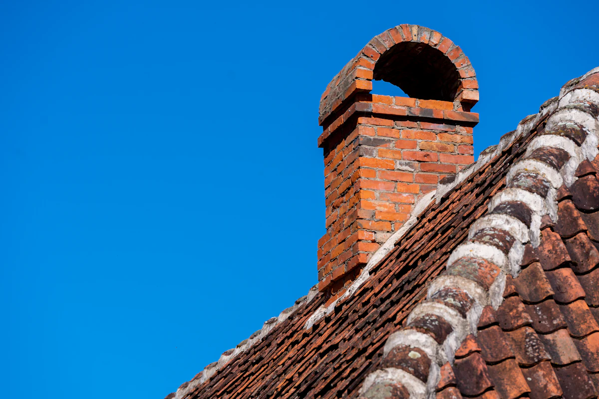 Rebuilt brick chimney against a clear blue sky