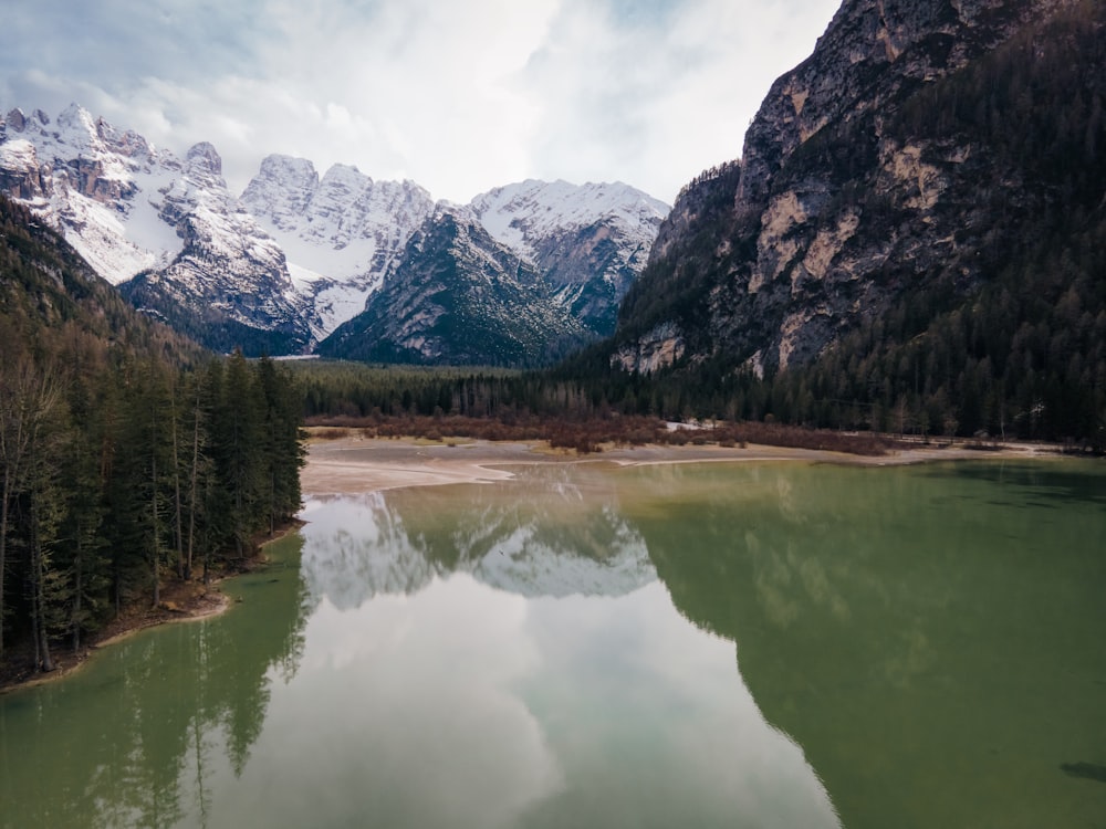 a lake surrounded by mountains in the middle of a forest