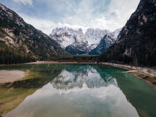 A serene mountain landscape with snow-capped peaks reflected in a crystal-clear lake.