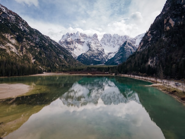 Meditation session beside a tranquil mountain lake surrounded by snow-capped peaks.