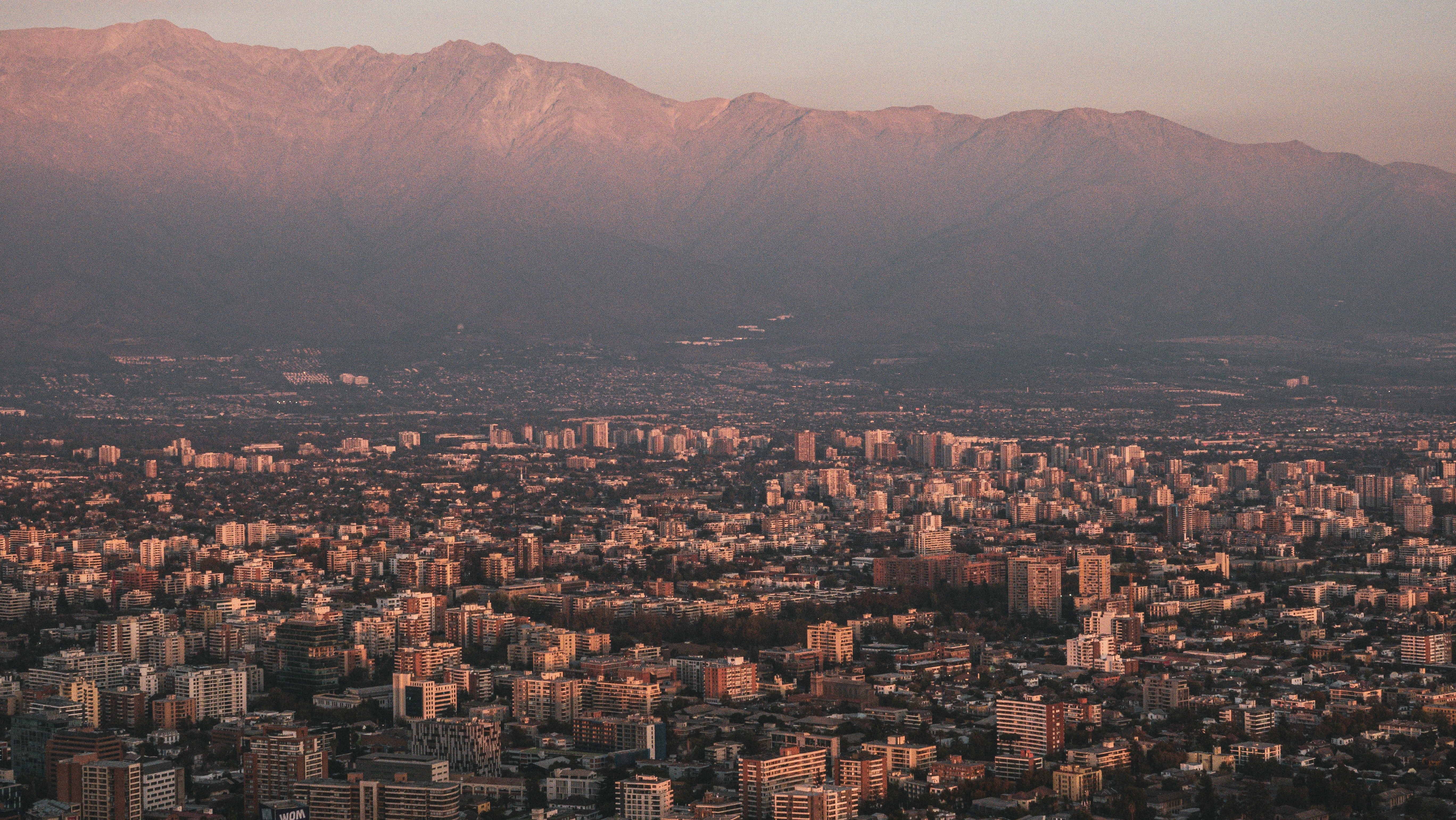 a view of a city with mountains in the background, 