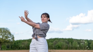 a woman is throwing a frisbee in a field