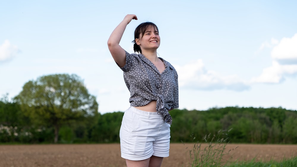 a woman standing in a field holding a frisbee