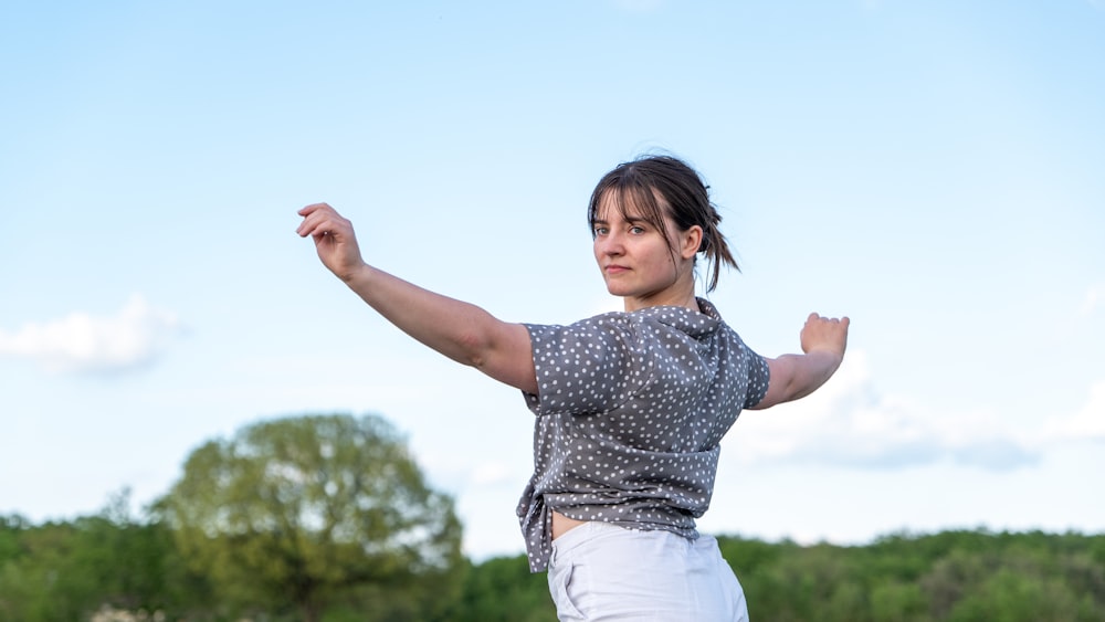 a woman is throwing a frisbee in a field