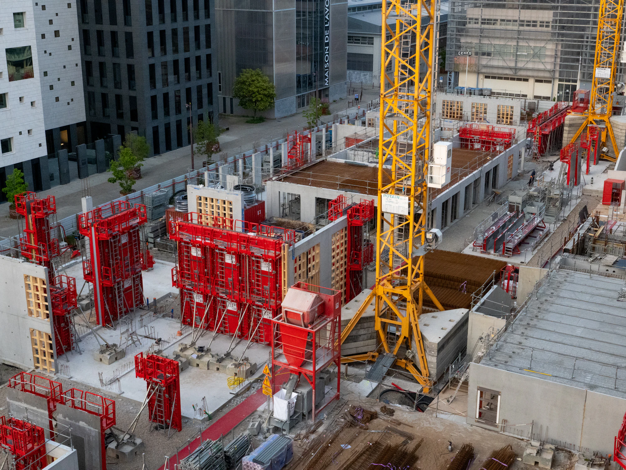 Canteiro de obras com fôrmas metálicas e gruas em edifício em estrutura