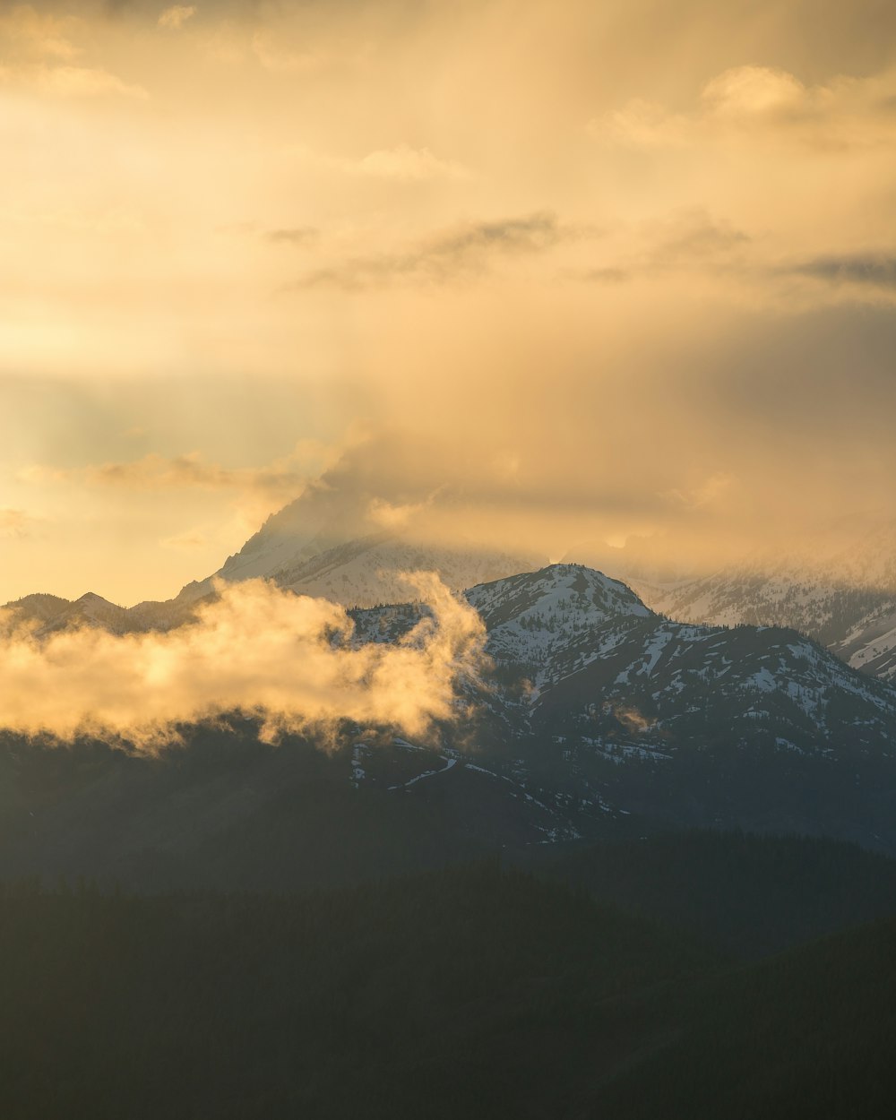 a view of a mountain range covered in clouds