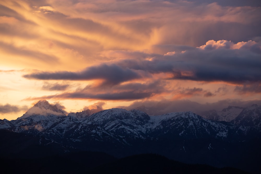 a view of a mountain range with clouds in the sky