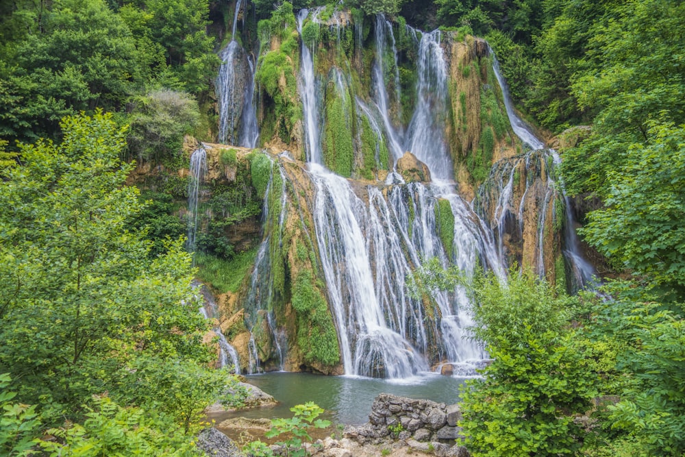 a large waterfall in the middle of a forest